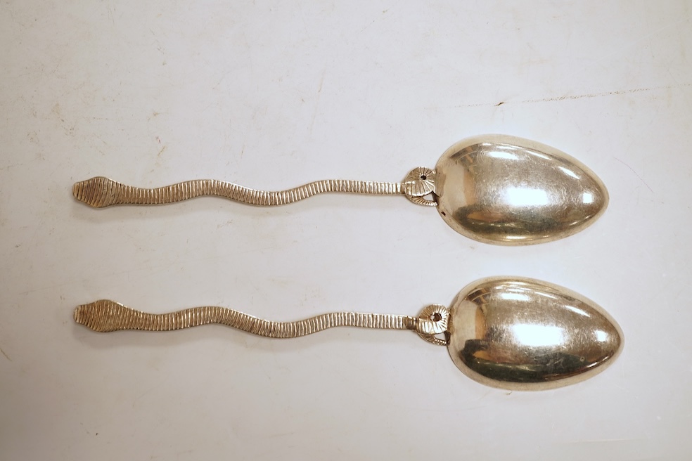 An 18th century silver apostle spoon, indistinct marks, 17cm, a continental white metal spoon with scroll handle and a pair of unmarked white metal spoons with serpent handles.